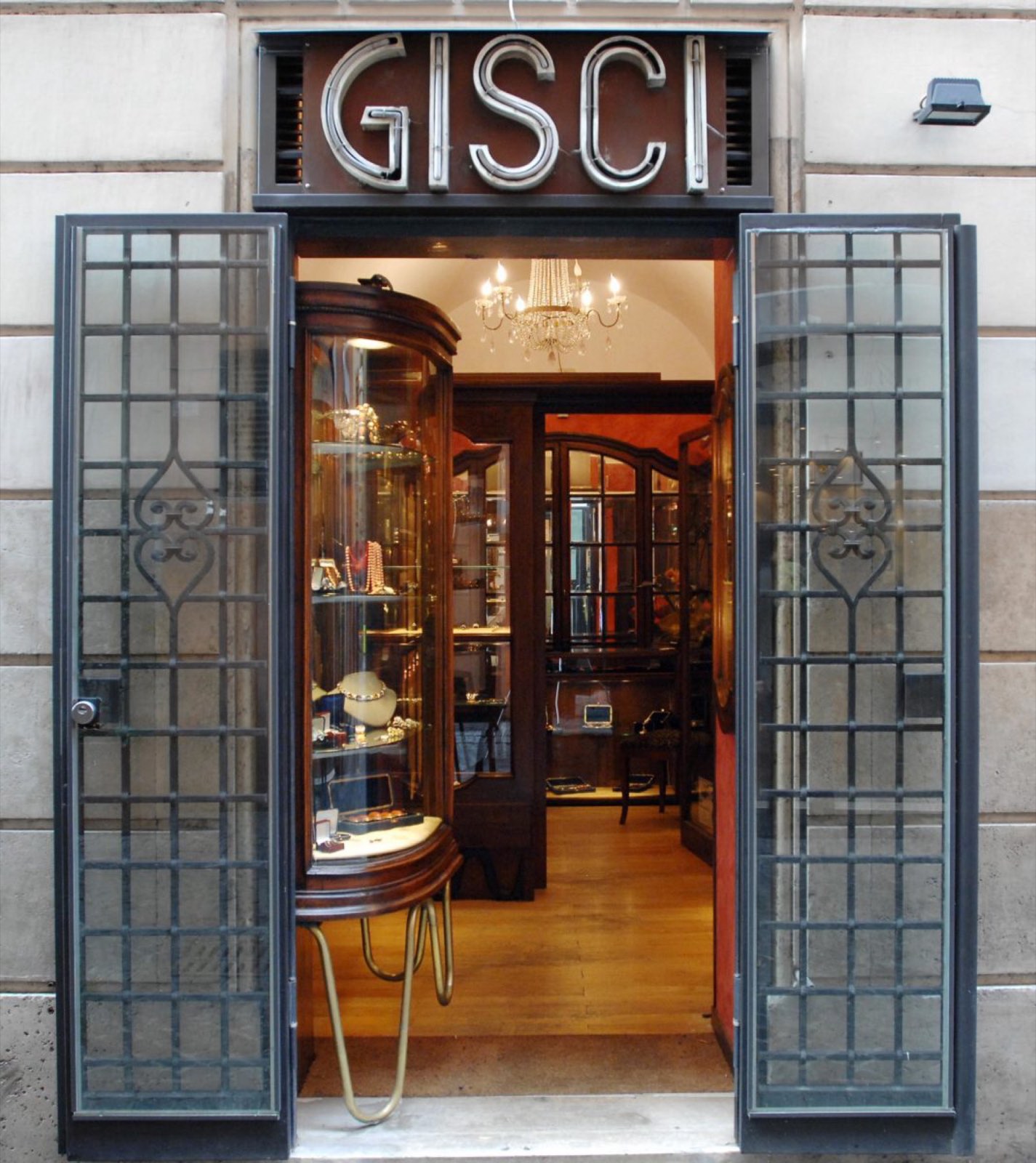 The open door of the Gisci boutique on Via Vittoria, with the historic sign above